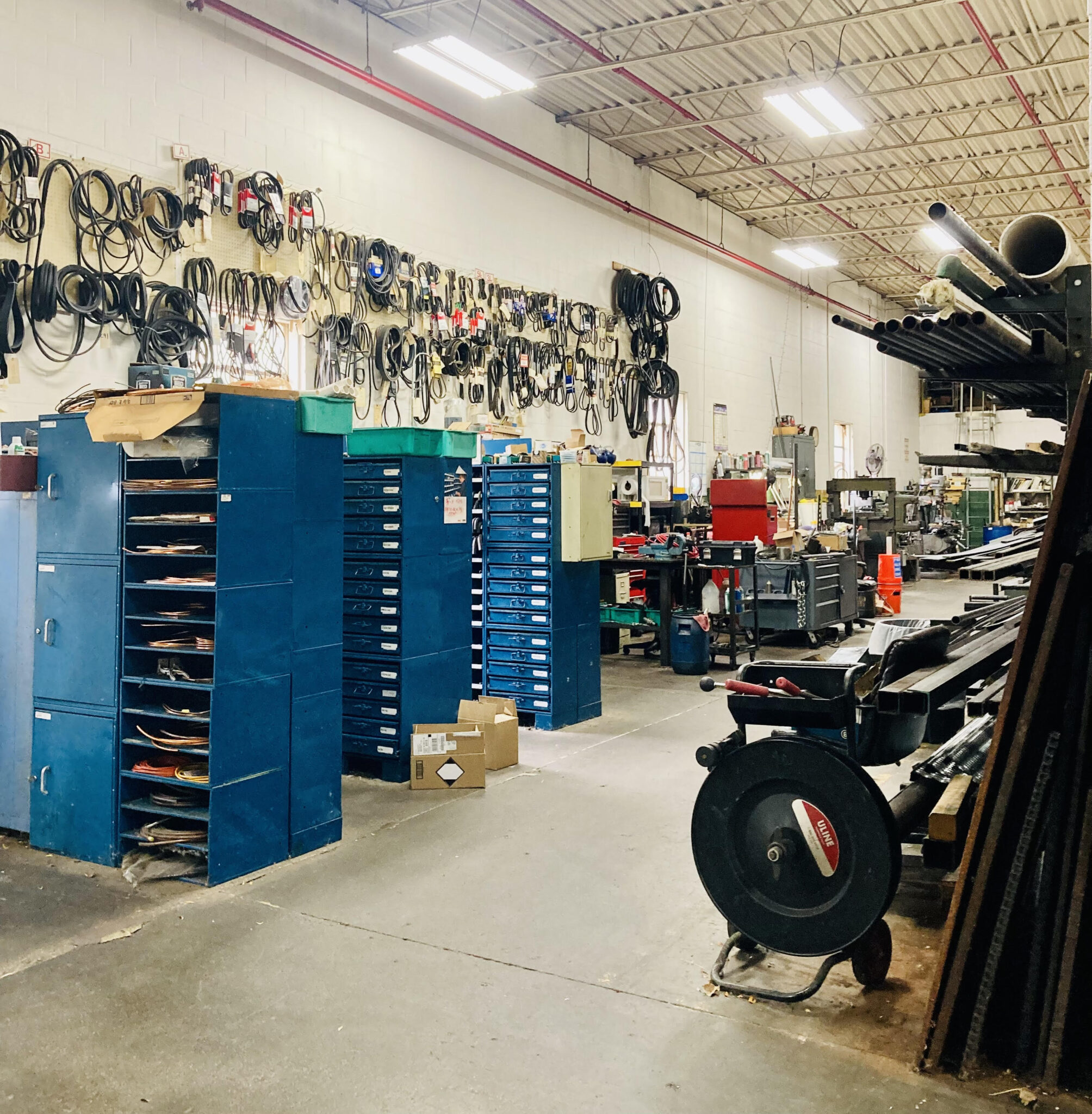 Assorted tools and blue shelves with equipment in the main maintenance area at Fastco.