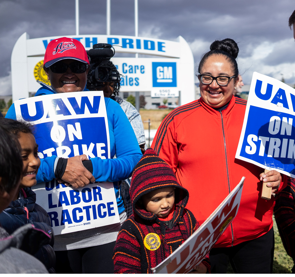 A man, woman, and child at UAW Strike